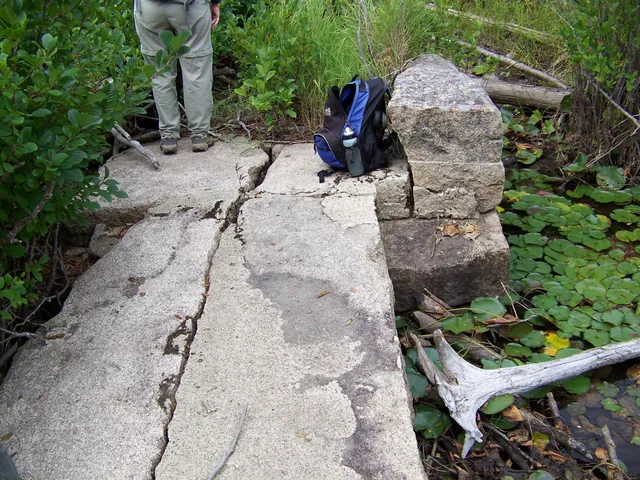 Close view of the bridge deck: two long granite slabs with a crack running along one of them