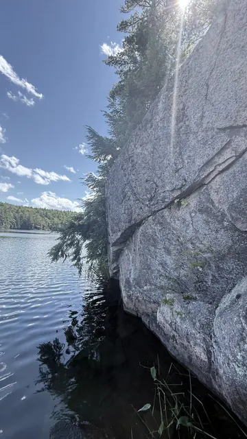 The same cliff in 2025, the water now right up against the rock