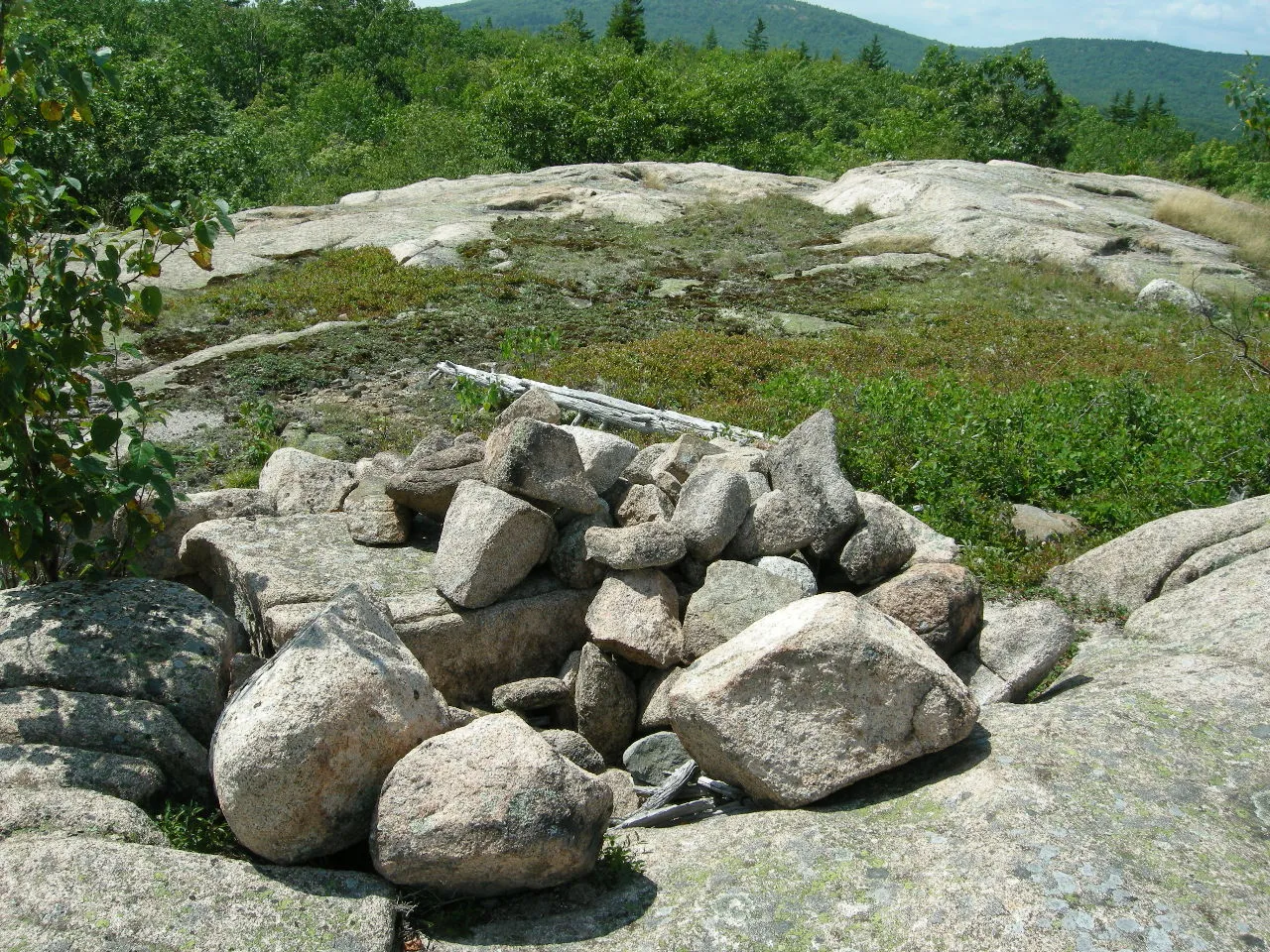 A low cairn of rounded stones on open granite ledge