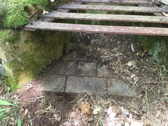 Looking under a grate at the firebrick lining of a fireplace